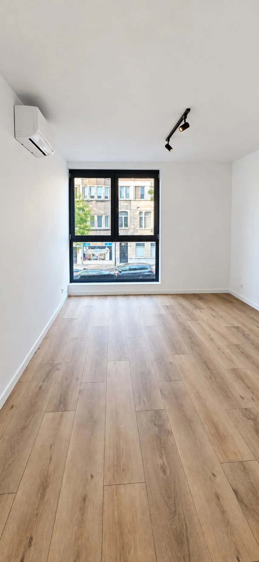 Afgewerkte kamer met houten vloer.